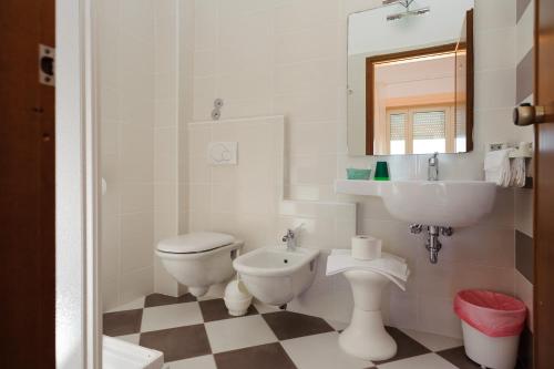 a white bathroom with a sink and a toilet at Hotel Residence Villa Jolanda in Lido di Camaiore