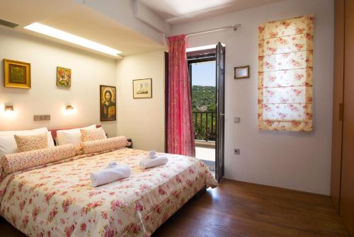a bedroom with a bed and a window at La Casa di Pietra Villas in Agios Nikolaos