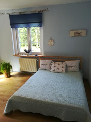 a bedroom with a large bed with two pillows at Leśna Polana in Lasowka