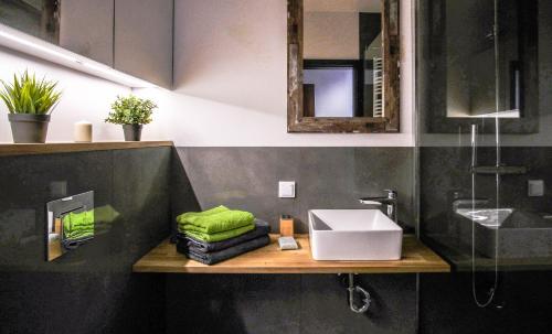 La salle de bains est pourvue d'un lavabo et d'un comptoir avec des serviettes vertes. dans l'établissement SUNRISE HOME w sercu Gdańska, à Gdańsk