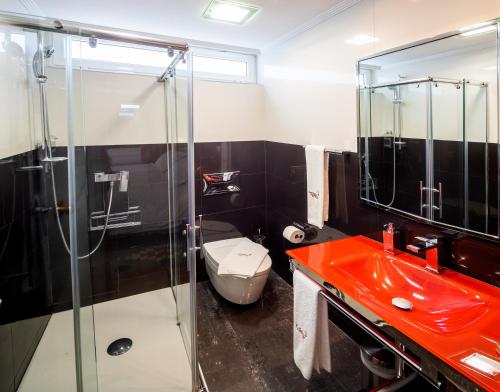 a bathroom with a red sink and a toilet at El Descanso de Wendy in Astorga