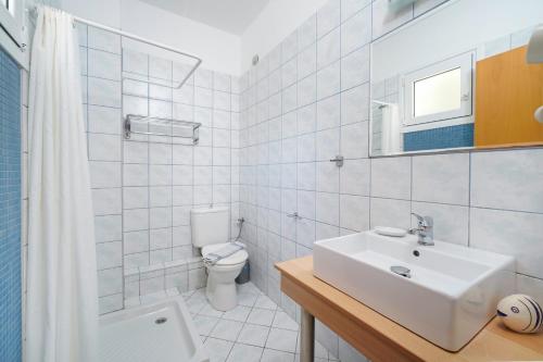 a white bathroom with a sink and a toilet at Kohylia by La Scala Beach in Limenas