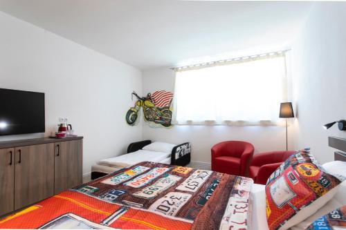 1 dormitorio con 1 cama, 1 silla y TV en Motel Eldorado, en Mikulov