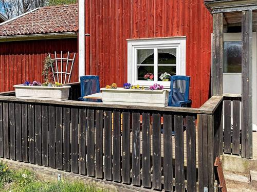 a deck with blue chairs and a red house at 7 person holiday home in LMEDBODA in Älmeboda