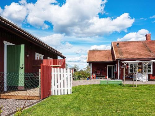 a house with a fence in front of a yard at 2 person holiday home in RIMFORSA in Rimforsa