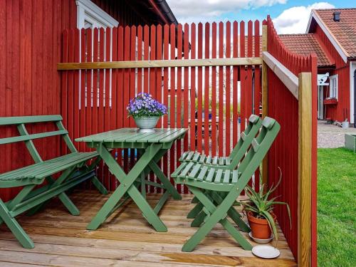 una mesa de picnic y dos sillas en una terraza junto a una valla en 2 person holiday home in RIMFORSA, en Rimforsa