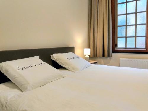 łóżko z dwoma białymi poduszkami na górze w obiekcie Pilgrim's Loft w mieście Ypres