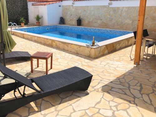 einen Pool im Garten mit Tisch und Stühlen in der Unterkunft Villa Sanda with Private Pool in Zadar