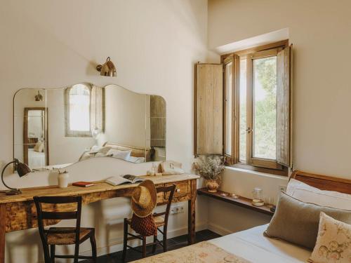 a bathroom with a sink and a desk with a mirror at Mas Generós - Adults-Only Eco Hotel in Fonteta