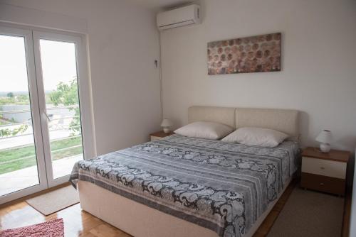 a bedroom with a bed and a large window at Dubis House in Zadar