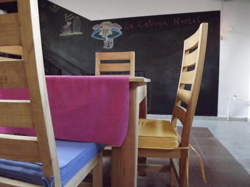 
a wooden table in a room with chairs at La Catrina Hostel in San Miguel de Allende
