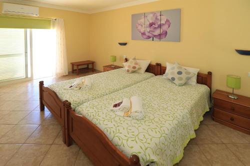 a bedroom with a bed with two dogs laying on it at venha nadar a oura in Albufeira