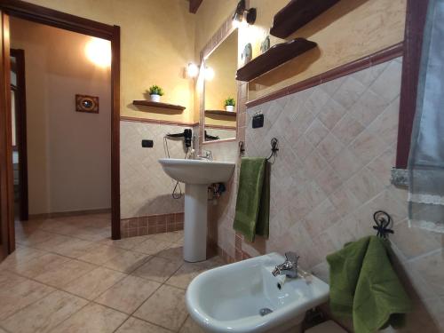 a bathroom with a sink and a toilet and a mirror at Villa Cruccuris in Villasimius
