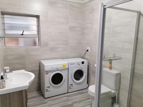 a bathroom with a washing machine and a sink at Surf Point 7 in Jeffreys Bay