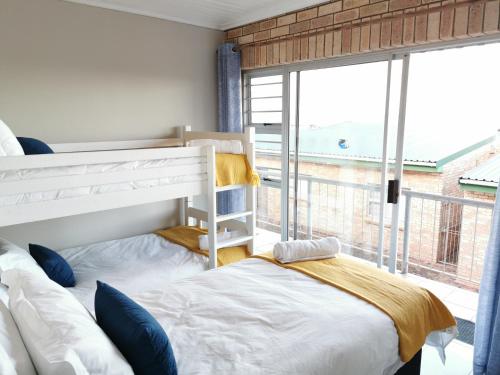a bedroom with a bunk bed and a large window at Surf Point 7 in Jeffreys Bay