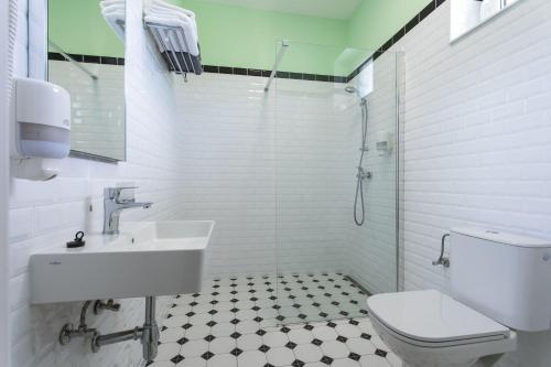 a white bathroom with a toilet and a sink at Motel Eldorado in Mikulov