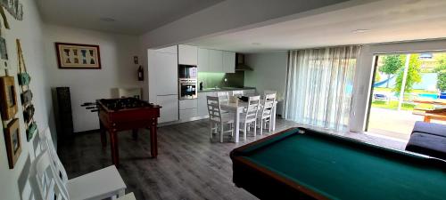 a living room with a pool table and a kitchen at Casa do Cerro in Madalena