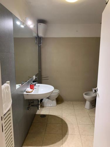 a bathroom with a sink and a toilet and a mirror at La Tela Bianca in Naples