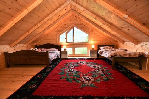 an attic room with two beds and a red rug at Holiday House by The Lake in Plav