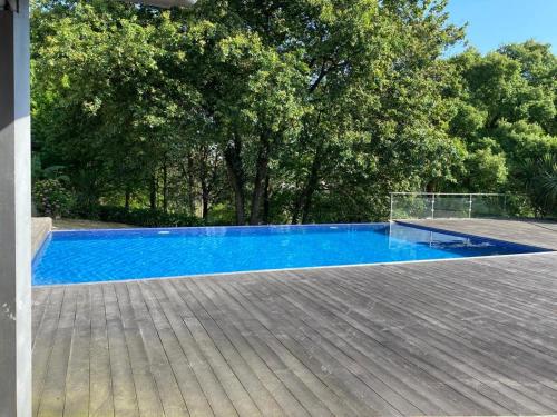 a large blue swimming pool with a wooden deck at Porto-Braga Country side - private swimming pool in Alvarelhos