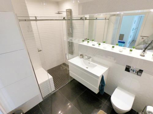 een badkamer met wastafel, douche en toilet bij White Dune Apartment - Self check-in in Klaipėda