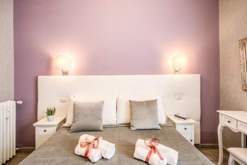 a bedroom with a large white bed with pink walls at Marta Inn in Rome