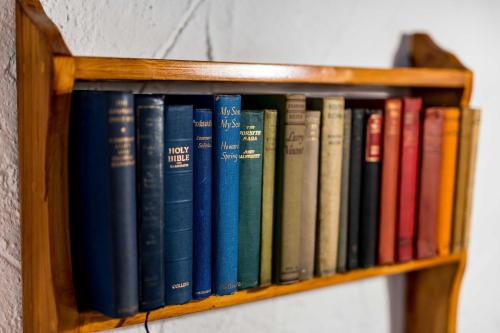 a row of books on a book shelf at Natura cottages in Makry Gialos