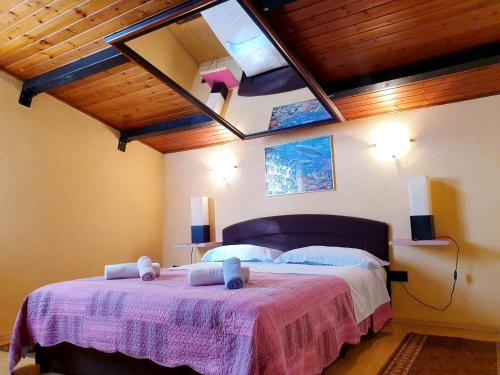 een slaapkamer met een groot bed en een dakraam bij Apartments Stošić in Rovinj