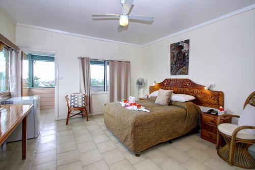 a bedroom with a bed and a table and chairs at King Solomon Hotel in Honiara