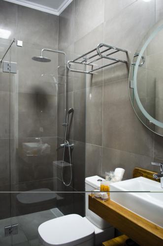 a bathroom with a shower and a toilet and a sink at Casa da Guarda in São João