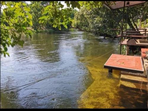 a river with a table in the middle of it at Kaengkrachan River Hut in Kaeng Krachan