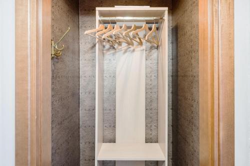 Un abito da sposa bianco appeso in un armadio di Golden Suite apartment & day use a Milano