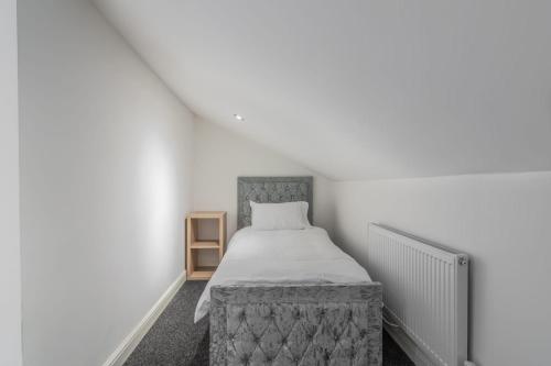 a bedroom with a bed in a white room at Fantastic brand new Rooms in Bury