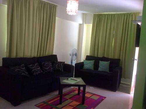 uma sala de estar com um sofá preto e uma mesa em Apartamento Aquarel em Boca Chica