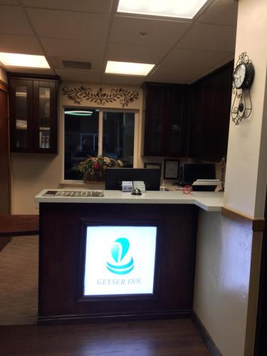 an office with a reception counter with a sign on it at Geyser Inn in West Yellowstone