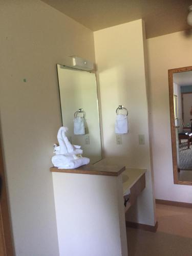 a bathroom with a mirror and towels on a counter at Malibu Inn in Wisconsin Dells