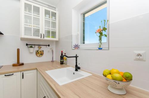 eine Küche mit einem Waschbecken und einer Schale Obst in der Unterkunft Villa Dupla Kanica in Sevid