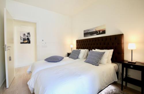 1 dormitorio con 1 cama blanca grande y 2 almohadas en Luxury Apartment by MyPlaceForYou, very quiet, close to Time Out Market Lisbon, en Lisboa