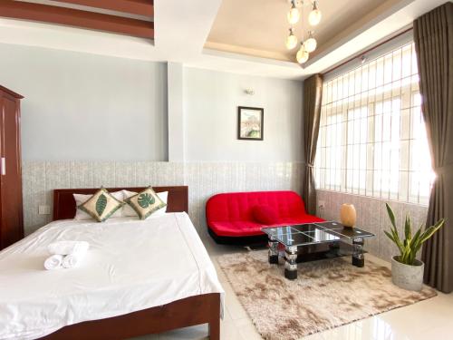 a bedroom with a bed and a red chair at Hue Lovely Homestay in Hue