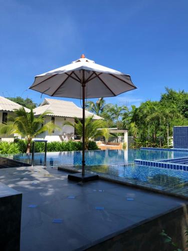 an umbrella sitting next to a swimming pool at Bulan Villa rayong in Rayong