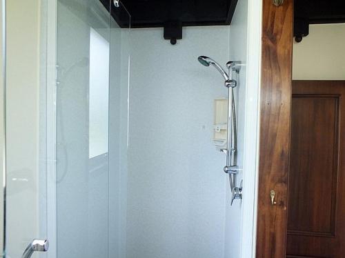 una ducha en un baño con puerta de cristal en Wharepekapeka - Russell Holiday Home, en Russell