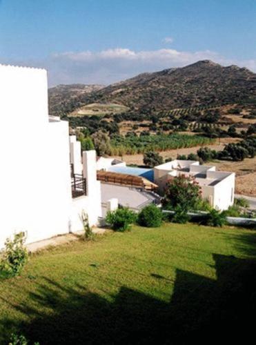 a white building with a field of green grass at Melissa Hotel in Matala