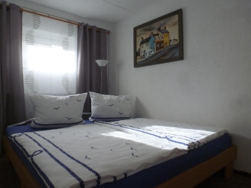 Una cama en un dormitorio con ventana. en Ferienwohnung Wieker Bodden, en Dranske