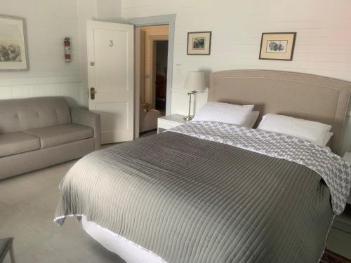 a bedroom with a large bed and a couch at Tofino Paddlers Inn in Tofino