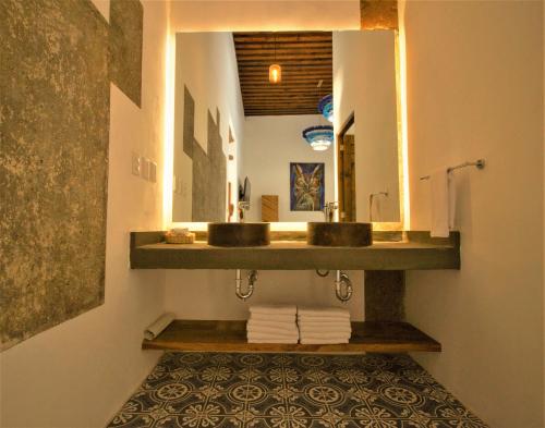 een badkamer met een wastafel en een spiegel bij NaNa Vida Hotel Morelia in Morelia