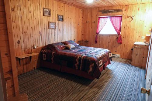 a bedroom with a bed in a wooden cabin at lake guest ranch in Devils Tower