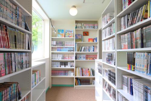 a library with white shelves filled with books at Human resort in Yamanakako
