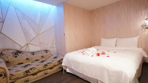 a bedroom with a white bed and a chair at Colors Infinity Inn in Taipei