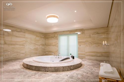 a large bathroom with a large tub in the middle at Nam Cuong Nam Dinh Hotel in Nam Ðịnh