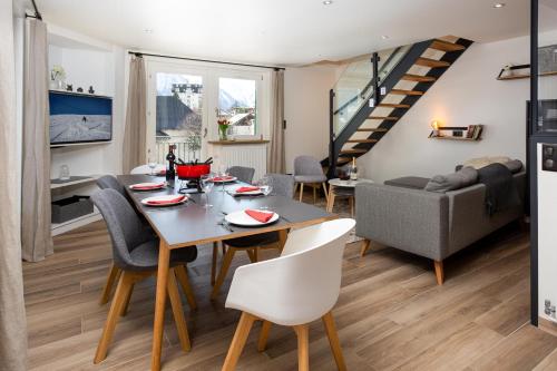 une salle à manger et un salon avec une table et des chaises dans l'établissement Le Panoramic Mont Blanc Apartment - Chamonix All Year, à Chamonix-Mont-Blanc